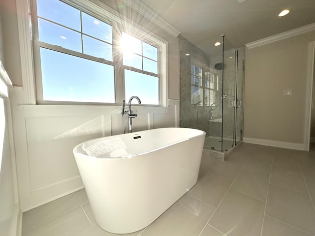 bathroom featuring a stall shower, a soaking tub, tile patterned flooring, and crown molding