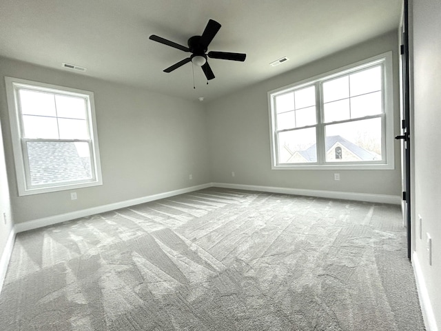 unfurnished room featuring a ceiling fan, carpet, visible vents, and baseboards