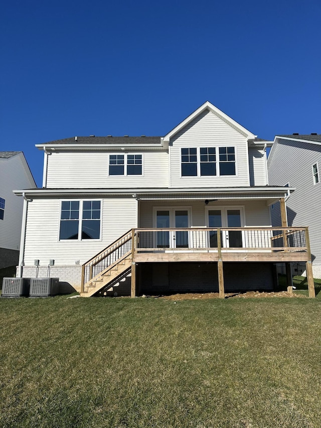 rear view of house with stairs, cooling unit, and a yard