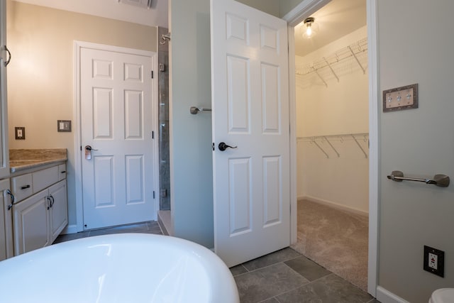 bathroom with tile patterned floors, vanity, and a bathing tub