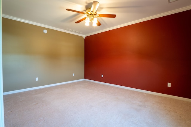 empty room featuring carpet floors, crown molding, and ceiling fan