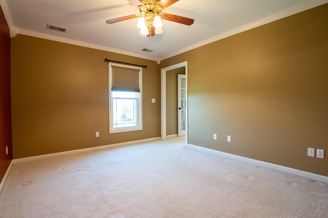 carpeted spare room featuring ceiling fan and crown molding