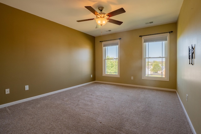 empty room featuring ceiling fan and light colored carpet