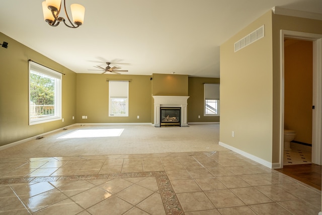 unfurnished living room featuring light tile patterned flooring and ceiling fan with notable chandelier