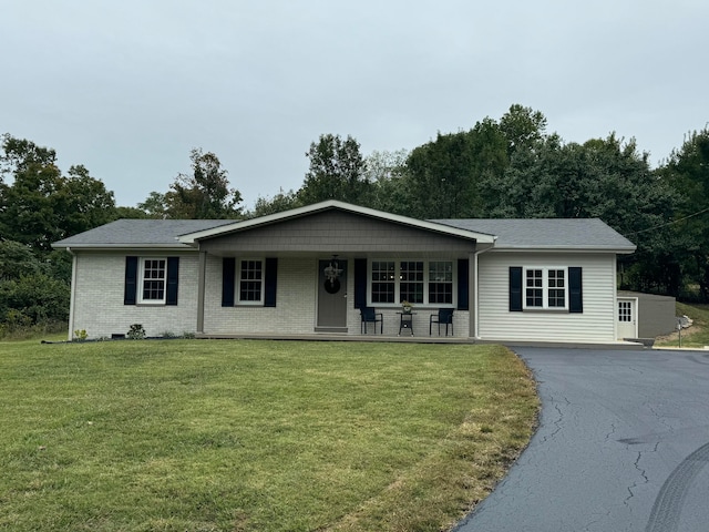 ranch-style house with a porch and a front lawn