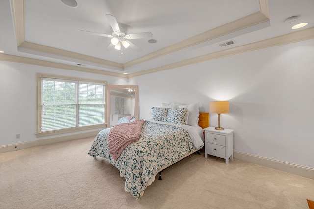 bedroom with a raised ceiling, crown molding, ceiling fan, and light colored carpet