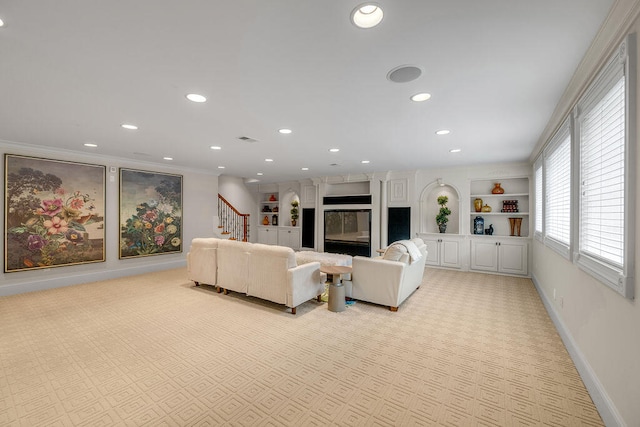 living room with built in features and ornamental molding