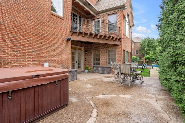 view of patio / terrace with a balcony and a hot tub