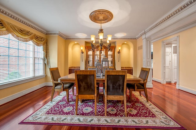 dining area featuring a chandelier, hardwood / wood-style floors, and crown molding