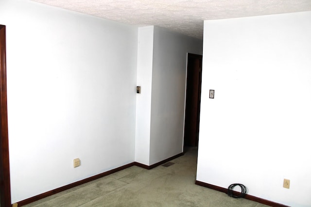 carpeted empty room featuring a textured ceiling