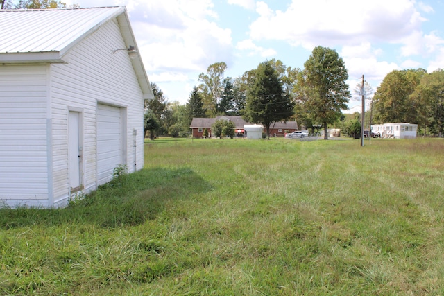 view of yard featuring a garage and an outdoor structure