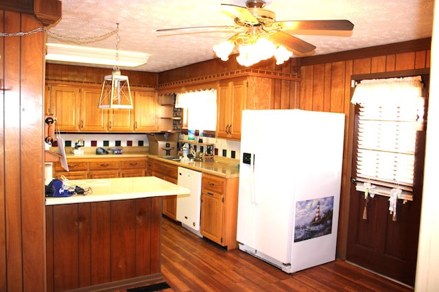 kitchen featuring white appliances, decorative light fixtures, dark hardwood / wood-style floors, and a healthy amount of sunlight