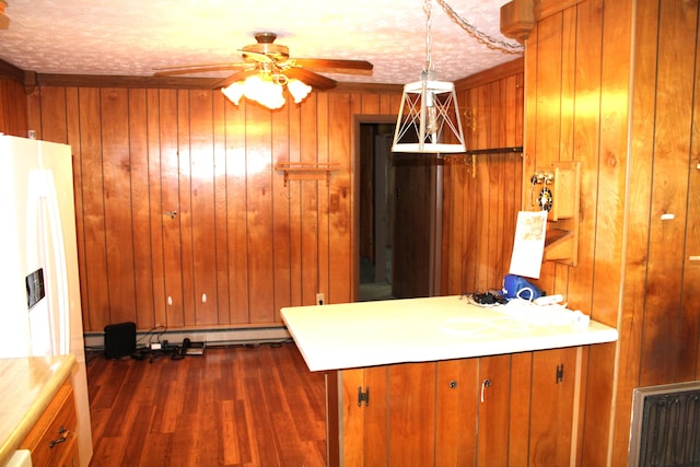 kitchen featuring wood walls, hanging light fixtures, ceiling fan, dark hardwood / wood-style flooring, and kitchen peninsula