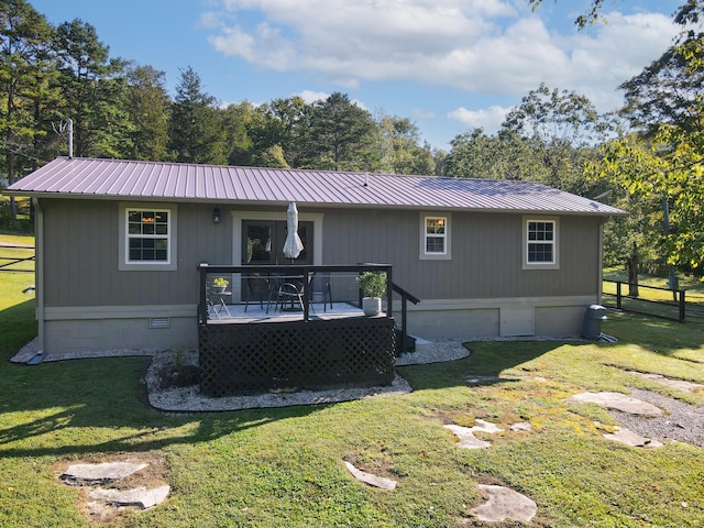 rear view of property featuring a lawn and a deck