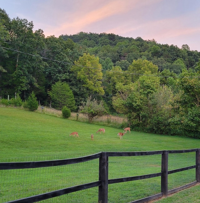 yard at dusk featuring a rural view