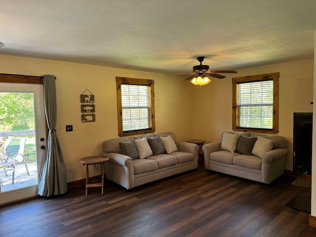 living room featuring ceiling fan, a textured ceiling, and dark hardwood / wood-style floors