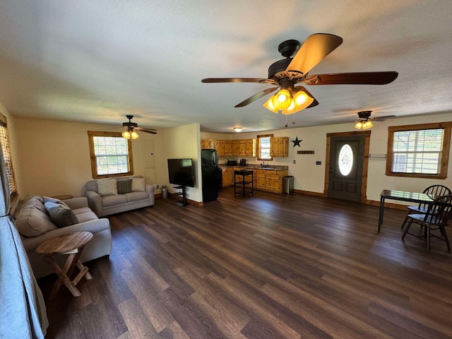 living room featuring ceiling fan, dark hardwood / wood-style flooring, and a healthy amount of sunlight