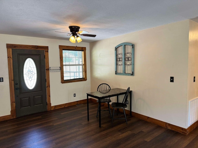 entryway with ceiling fan, a textured ceiling, and dark wood-type flooring