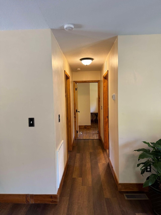 corridor with dark hardwood / wood-style flooring