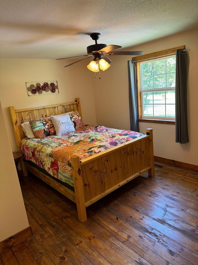 bedroom featuring a textured ceiling, dark hardwood / wood-style flooring, and ceiling fan