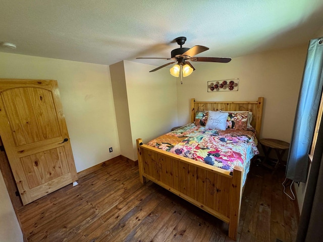 bedroom with a textured ceiling, ceiling fan, and dark wood-type flooring