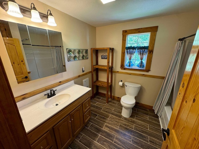 bathroom featuring vanity, toilet, and a textured ceiling