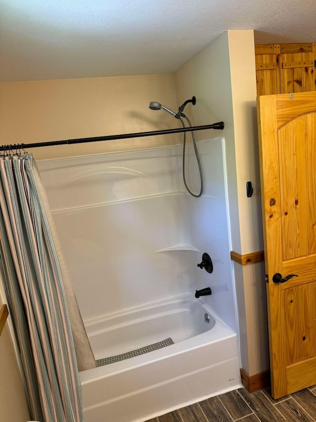 bathroom featuring a textured ceiling, hardwood / wood-style floors, and shower / bathtub combination with curtain