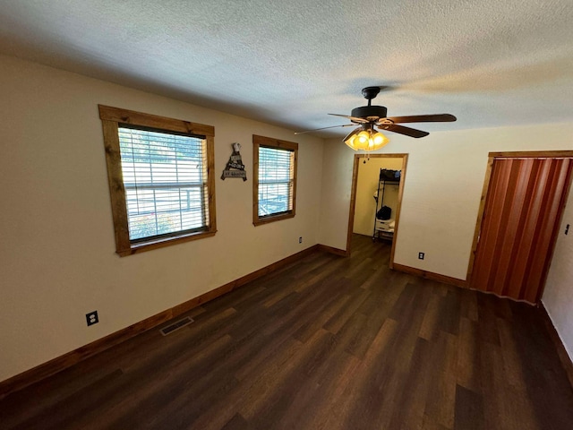 interior space with a textured ceiling, ceiling fan, and dark hardwood / wood-style flooring