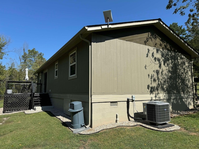 view of side of property with a lawn and central AC