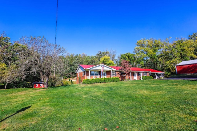 view of front of home with a front yard and an outbuilding