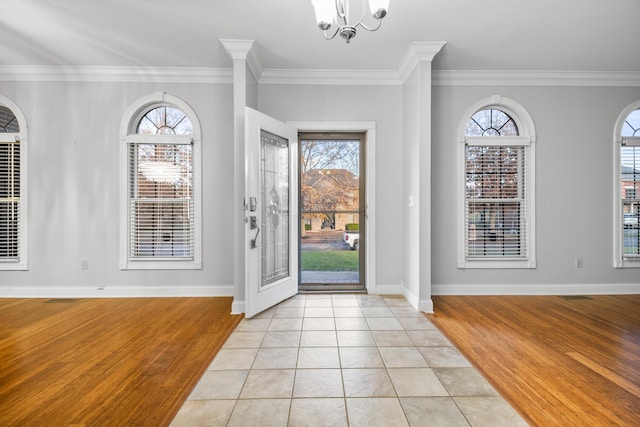 tiled foyer entrance featuring a notable chandelier and ornamental molding