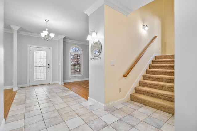 tiled entrance foyer featuring a chandelier and ornamental molding