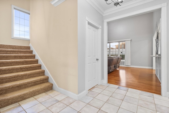 interior space with tile patterned floors, ornamental molding, and a notable chandelier