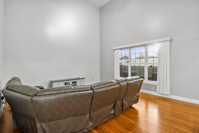 living room with wood-type flooring and a high ceiling