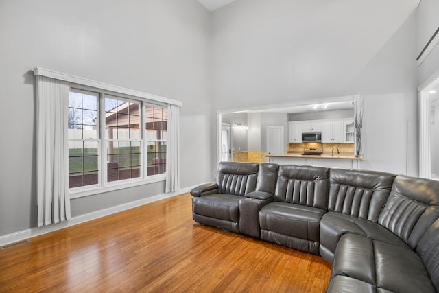 living room featuring a high ceiling and light wood-type flooring