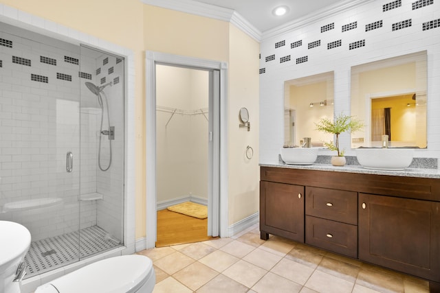 bathroom featuring tile patterned floors, walk in shower, vanity, crown molding, and toilet