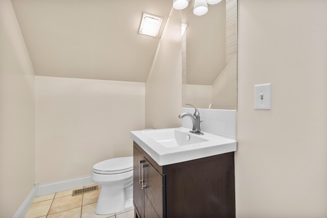 bathroom featuring tile patterned floors, vanity, toilet, and lofted ceiling