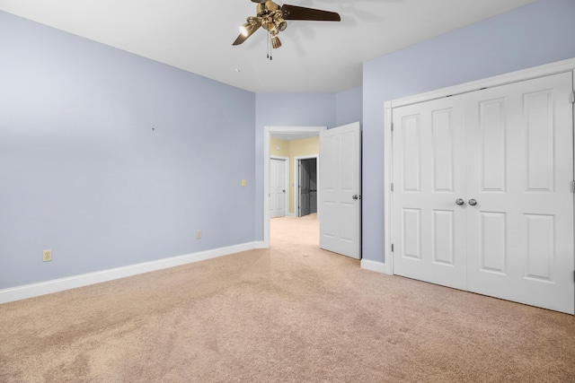 unfurnished bedroom with ceiling fan, a closet, and light colored carpet