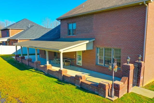 back of house featuring a lawn, area for grilling, and a patio