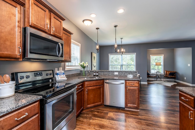 kitchen featuring pendant lighting, sink, stainless steel appliances, a notable chandelier, and dark hardwood / wood-style flooring