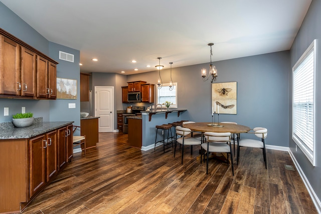 dining room featuring dark hardwood / wood-style flooring, a chandelier, and sink