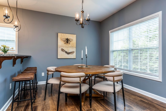 dining space with dark hardwood / wood-style flooring and a chandelier