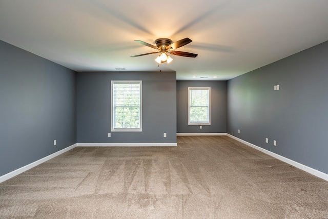 carpeted spare room with ceiling fan