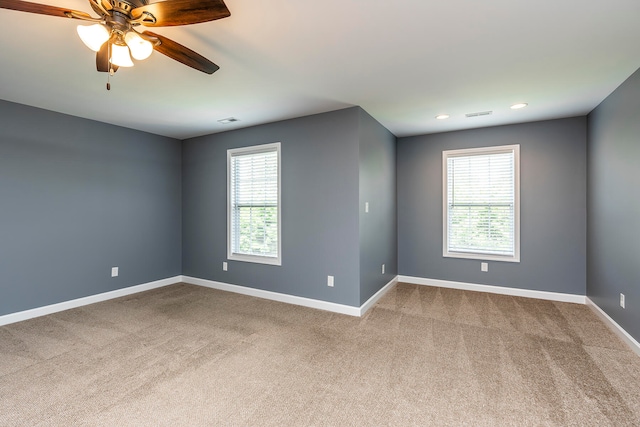 spare room with ceiling fan and carpet