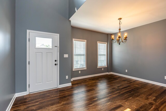 foyer entrance with a notable chandelier and dark hardwood / wood-style flooring