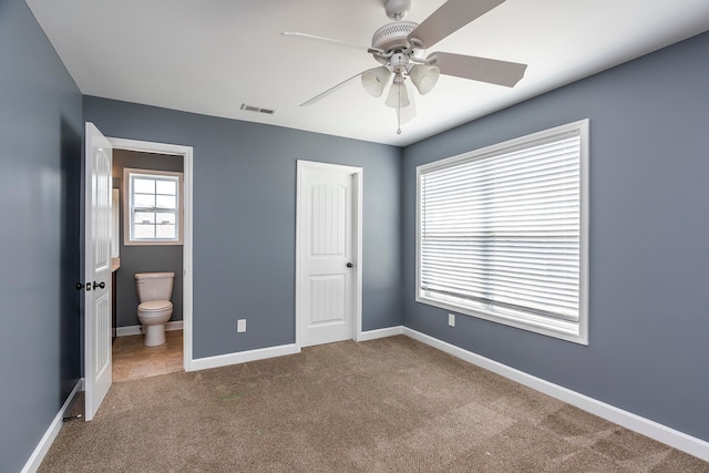 unfurnished bedroom with carpet, ceiling fan, and ensuite bathroom