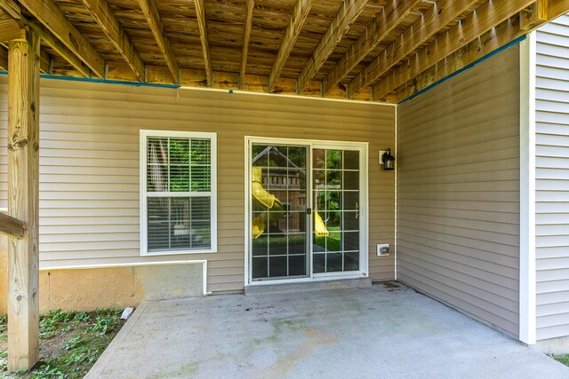 view of exterior entry featuring a patio area