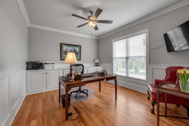 office featuring a ceiling fan, light wood-style flooring, wainscoting, and ornamental molding