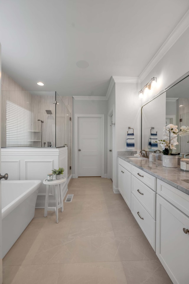 full bath featuring vanity, a shower stall, a soaking tub, and crown molding