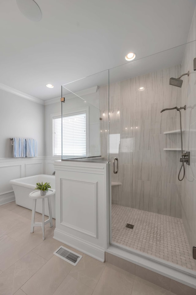 bathroom featuring tile patterned floors, visible vents, a soaking tub, and a stall shower